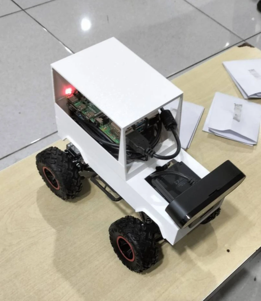AGV prototype — Raspberry Pi and camera mounted on an RC chassis with a 3D-printed body